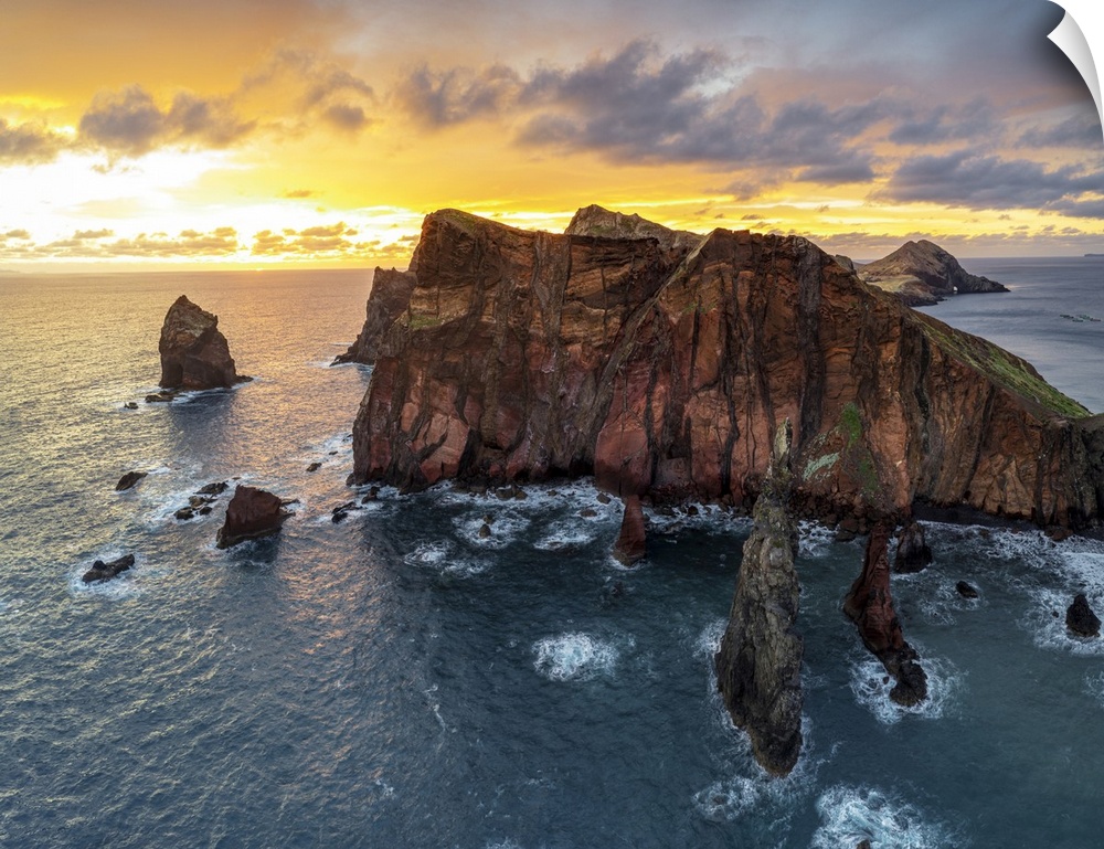 Burning sky at dawn on cliffs washed by ocean, Ponta do Rosto viewpoint, Sao Lourenco Peninsula, Madeira island, Portugal,...