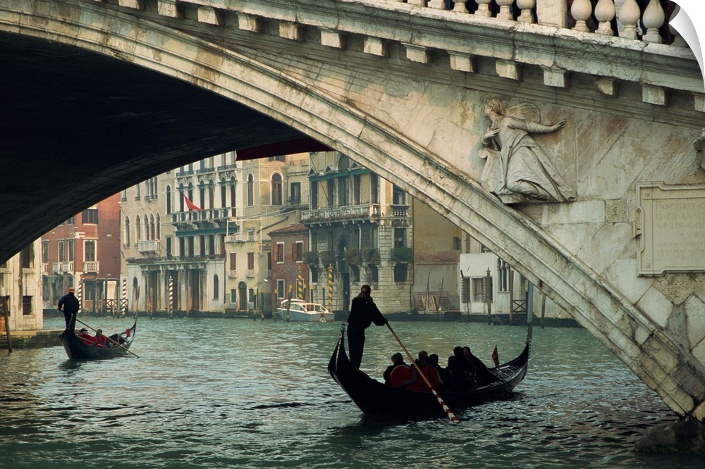 Gondola under the Rialto Bridge on the Grand Canal in Venice, Italy