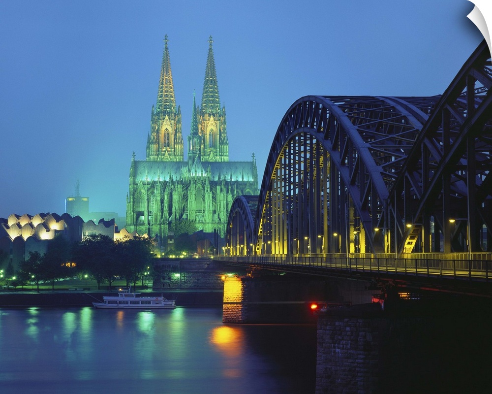 Hohenzollernbrucke and the Cathedral Illuminated at Night, Cologne, Germany.