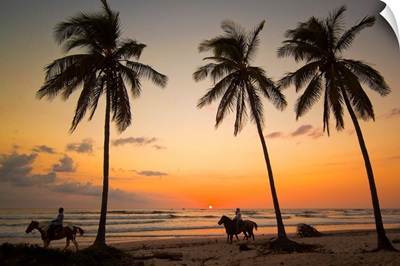 Horse riders at sunset, Playa Guiones surfing beach, Costa Rica