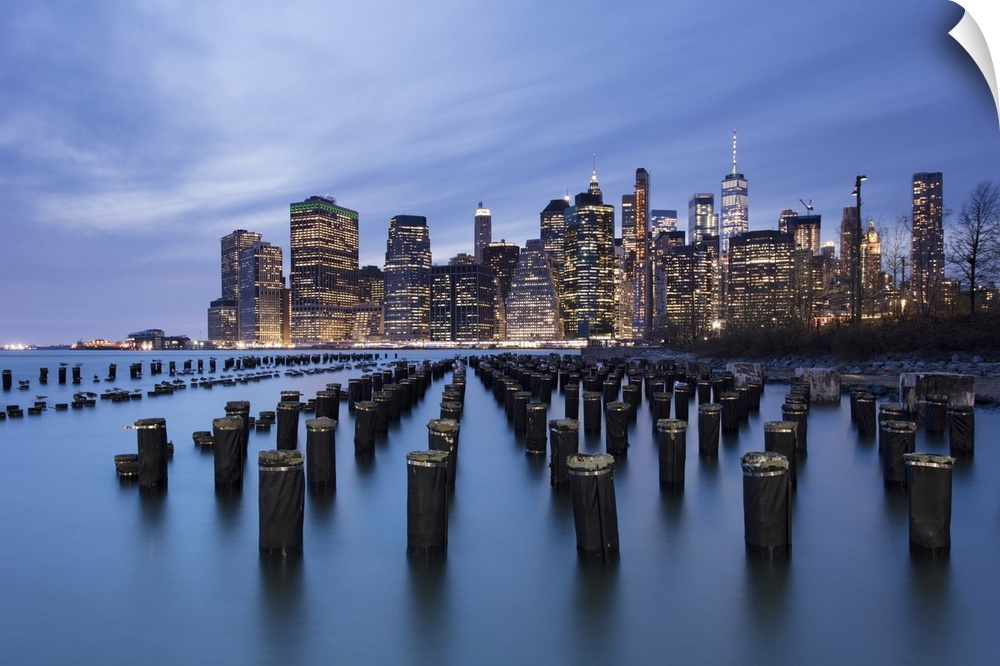 Lower Manhattan skyline with wooden posts from an old pier in the foreground. New York City, New York, United States of Am...