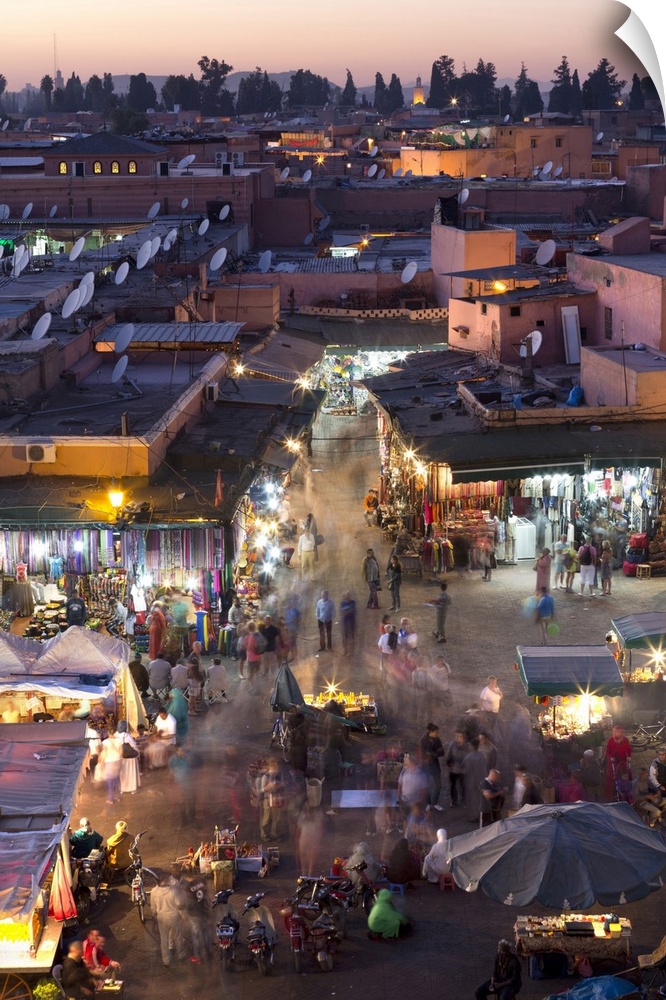 Crowds of locals and tourists walking among the shops and stalls in the Djemaa el Fna at sunset, Marrakech, Morocco, North...