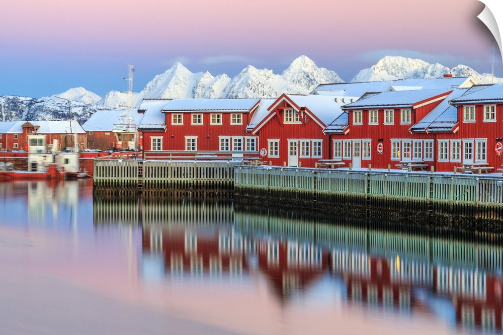 Pink sunset over the typical red houses reflected in the sea, Svolvaer, Lofoten Islands, Arctic, Norway, Scandinavia, Europe