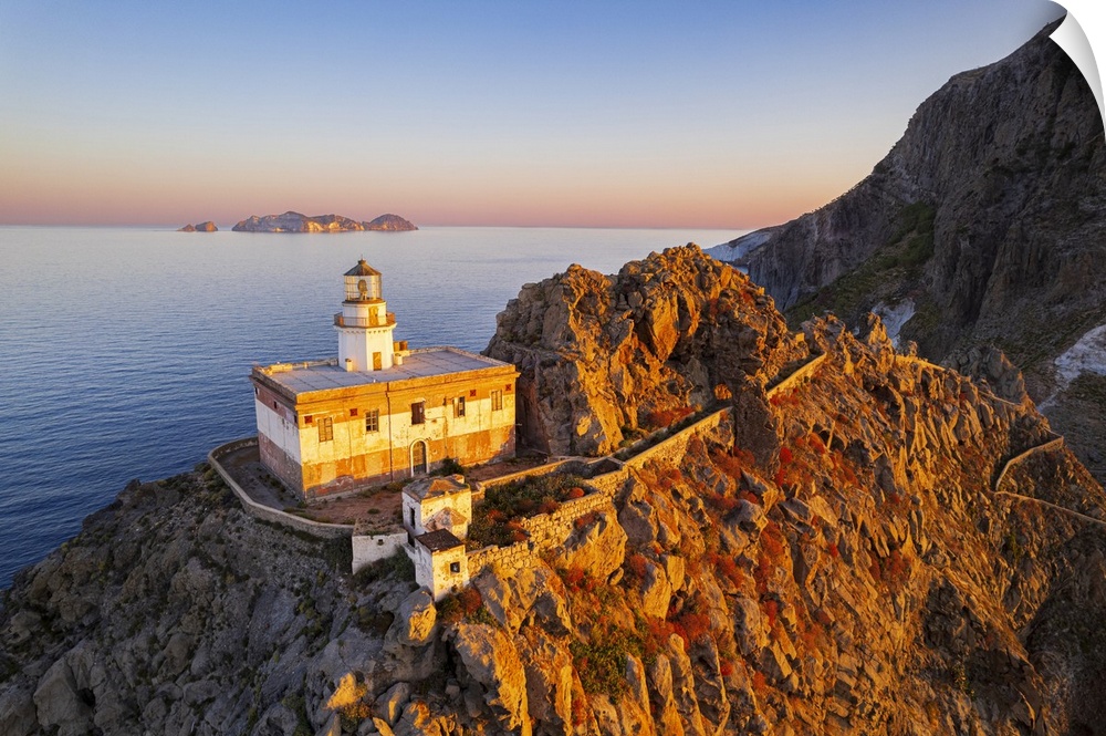 Aerial view of Punta della Guardia lighthouse on top of a cliff on the island of Ponza, lit from sunrise, Ponza island, Po...