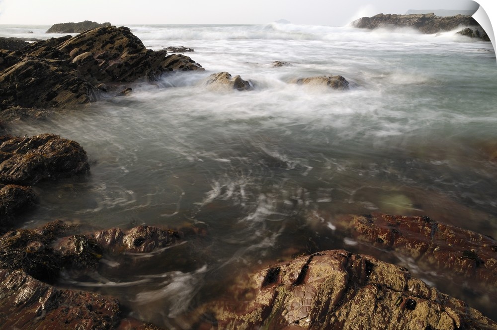 Sea swirling around rocks, near Polzeath, Cornwall, England, UK