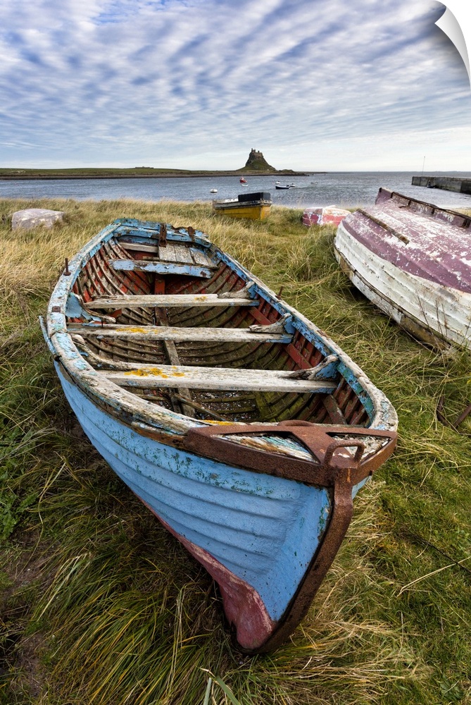 View towards Lindisfarne Castle with an old blue and red fishing boat in the foreground, Lindisfarne (Holy Island), Northu...