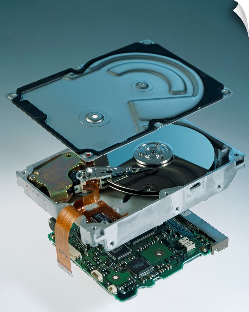 Computer hard disk assembly. Component parts of a hard disk showing the outer aluminium casing (top), the hard disk platte...