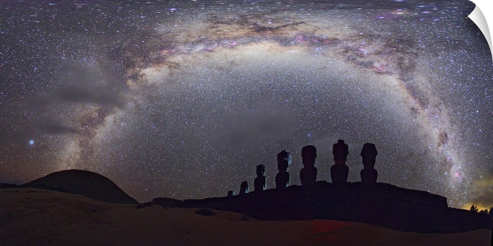 Easter Island moai and Milky Way. Panoramic view of the arch of the Milky Way in the night sky over silhouetted moai statu...
