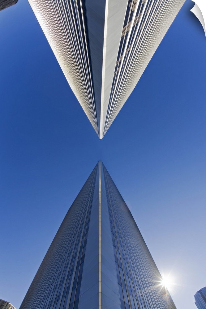 Photograph of two skyscrapers from below looking up.