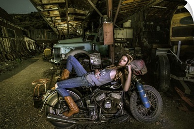Blonde girl laying on an old Harley Davidson