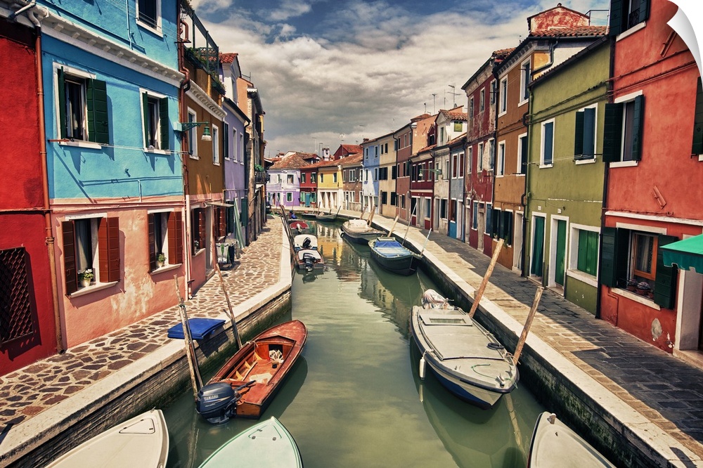 This landscape photograph shows a narrow canal lined with vividly colorful houses.
