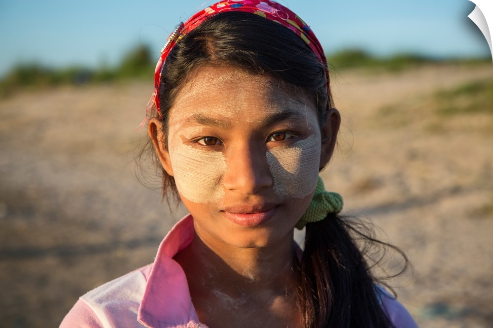 Burmese girl with facepaint at sunrise, Mandalay, Burma.