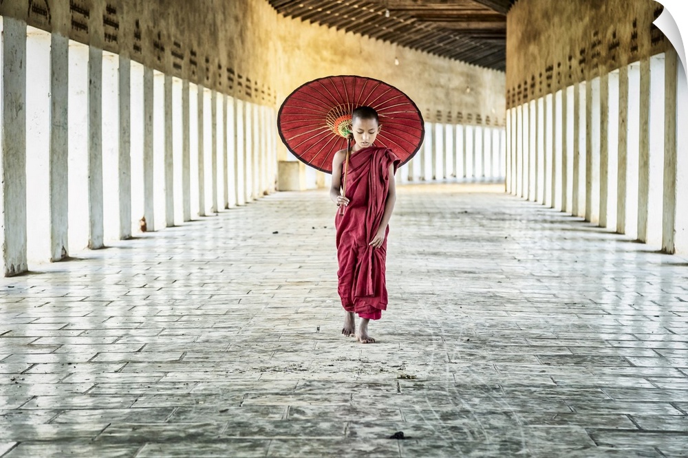 Burmese monk with parasol walking in his monastery