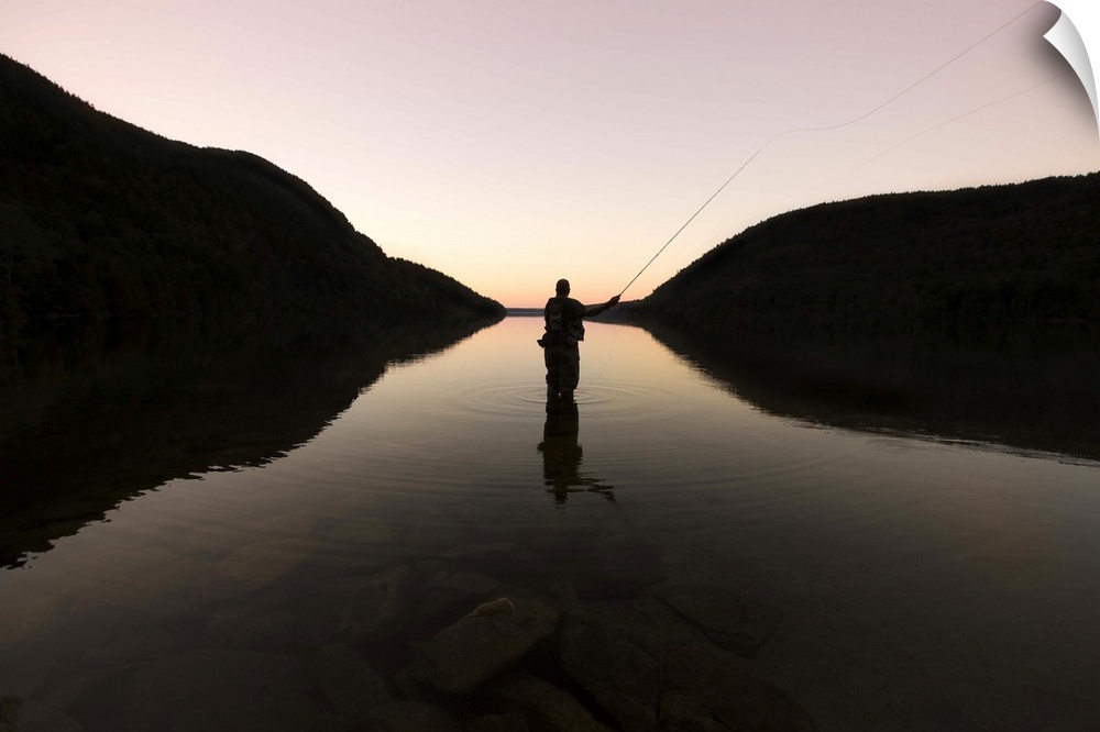 Fly fisherman at sunset in Long Pond, Maine
