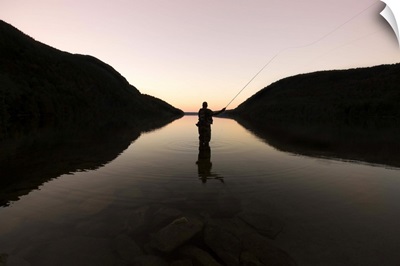 Fly fisherman at sunset in Long Pond, Maine