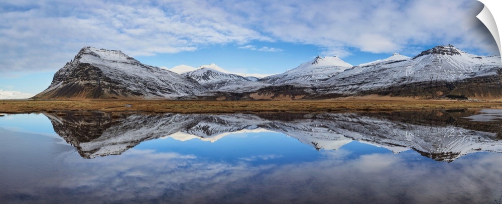 Snow covered mountain panorama reflecting in a lake in Iceland.