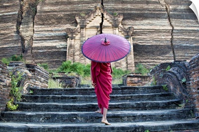 Monk with parasol walking up the steps to Mingun Monastery in Burma