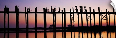 People walking across the UBein bridge at sunset in Mandalay