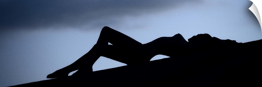 Silhouette of a nude woman outdoors at dusk