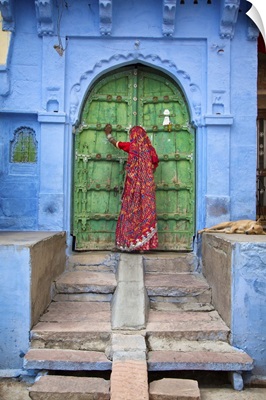 Woman knocking on door in the Blue City of Jodphur, India