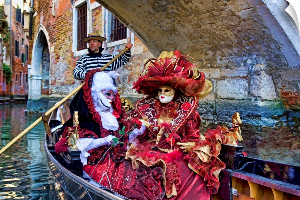 Women in masquerade outfits on a gondola at Carnival in Venice, Italy