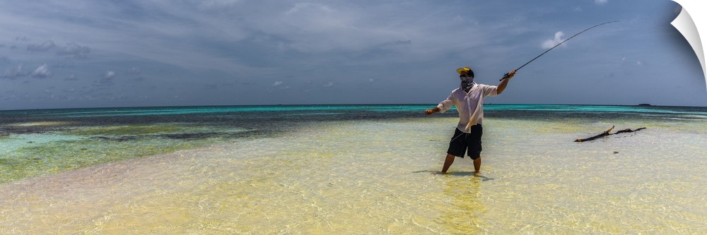 A man fly fishing in the ocean on a tropical beach in Belize, 2016.