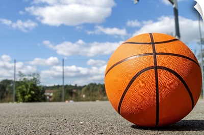 Basketball on an outdoor court on a sunny day