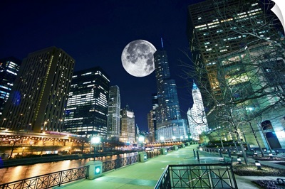Dramatic view of Chicago at night, with large moon in the sky