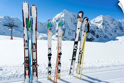Skis sticking in the snow on a mountain slope.
