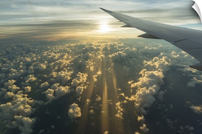 View From Airplane Side Window Of Sunset Sky And Sunlit Clouds