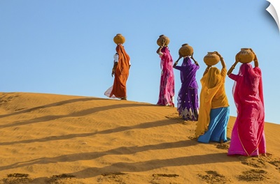 Women Carrying Jugs Of Water In The Hot Summer Desert