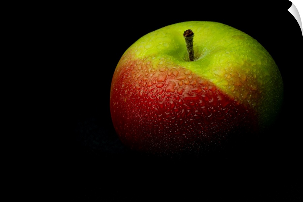 A close up photograph of a fresh Macintosh apple with waterdrops.