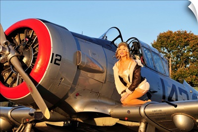 1940's style aviator pin-up girl posing with a vintage T-6 Texan aircraft