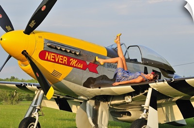 1940's style pin-up girl lying on the wing of a P-51 Mustang