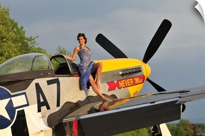 1940's style pin-up girl standing barefoot on the wing of a P-51 Mustang