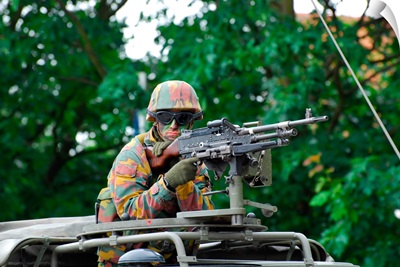 A Belgian Army soldier handling a machine gun atop a Unimog vehicle