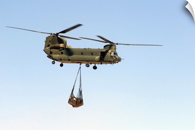 A CH 47 Chinook of the Royal Air Force transports a sling load of pallets