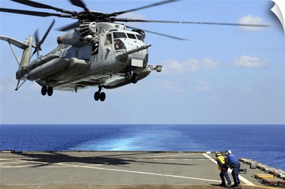 A CH-53E Super Stallion lifts off from an amphibious dock landing ship
