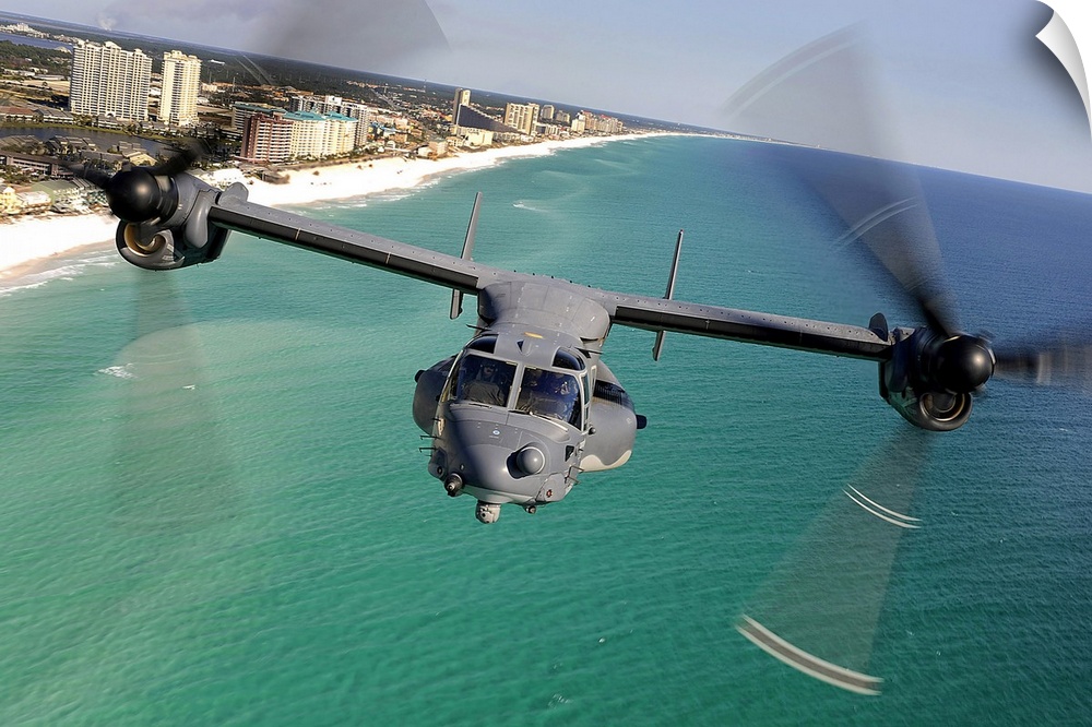 Large landscape photograph of a CV22 Osprey aircraft flying toward the camera, over the green and blue waters of the Emera...