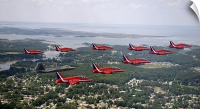 A F-22 Raptor Flies In Formation With The Royal Air Force Aerobatic Team, The Red Arrows