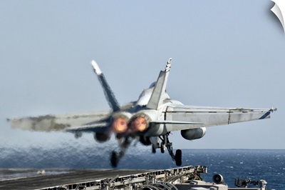 A F/A-18F Super Hornet launches from the flight deck of aircraft carrier USS Nimitz