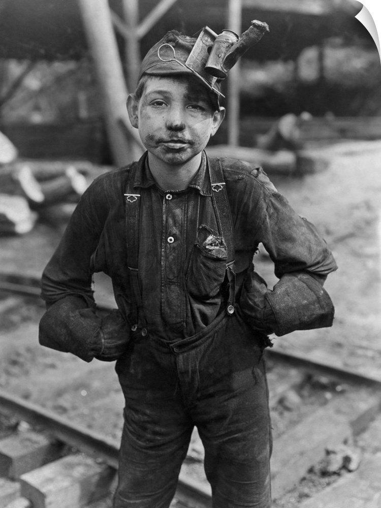 A filthy young coal miner after a long day of work in the mines of West Virginia.