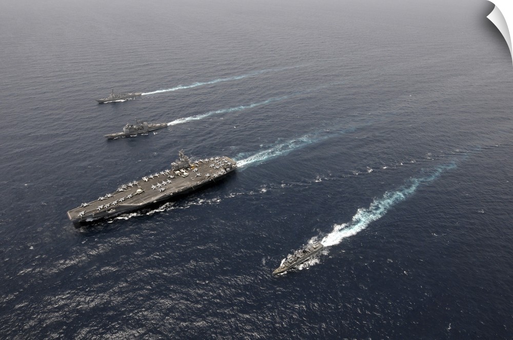A formation of ships traveling at sea.