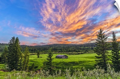 A high dynamic range photo of a sunset over a log cabin