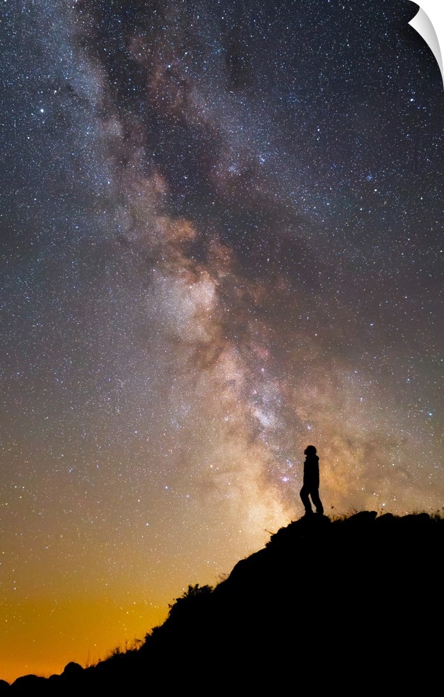 A man on a mountain under the Milky Way on the Lago-Naki plateau in Russia.