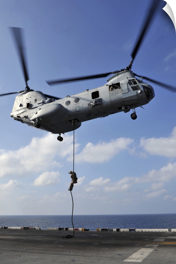 Arabian Sea, January 12, 2012 - A Marine fast ropes from a CH-46E Sea Knight helicopter onto the flight deck of the amphib...