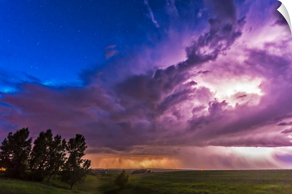June 20, 2014 - A massive thunderstorm moves across the northern horizon lit internally by lightning. The clear sky behind...