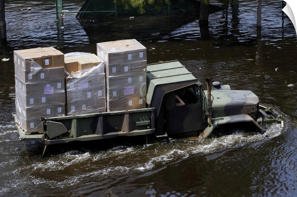 A National Guard M817 5-ton Dump Truck fords the floodwaters left by Hurricane Katrina to take supplies to the Super Dome ...