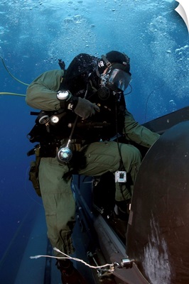 A Navy SEAL climbs aboard a SEAL Delivery vehicle before launching from a submarine