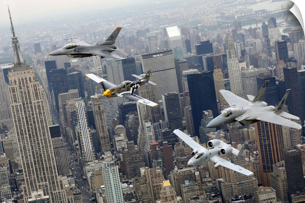 Photograph of military jets flying over city buildings on a foggy day.